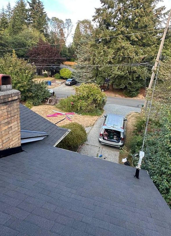 Chimney flashing and adjoining roof shingles after roofing work